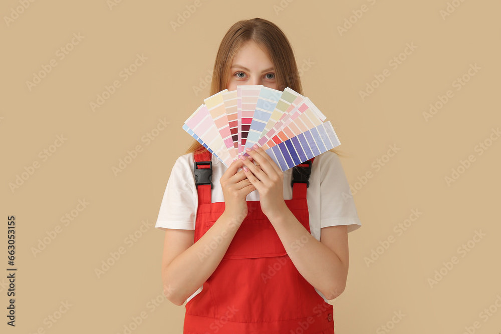 Female decorator with color samples on beige background