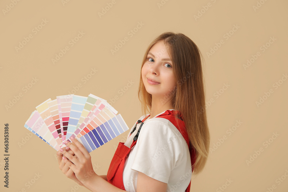 Female decorator with color samples on beige background