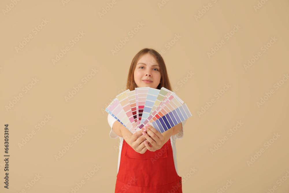 Female decorator with color samples on beige background