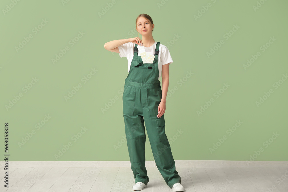 Female decorator with color samples on green background