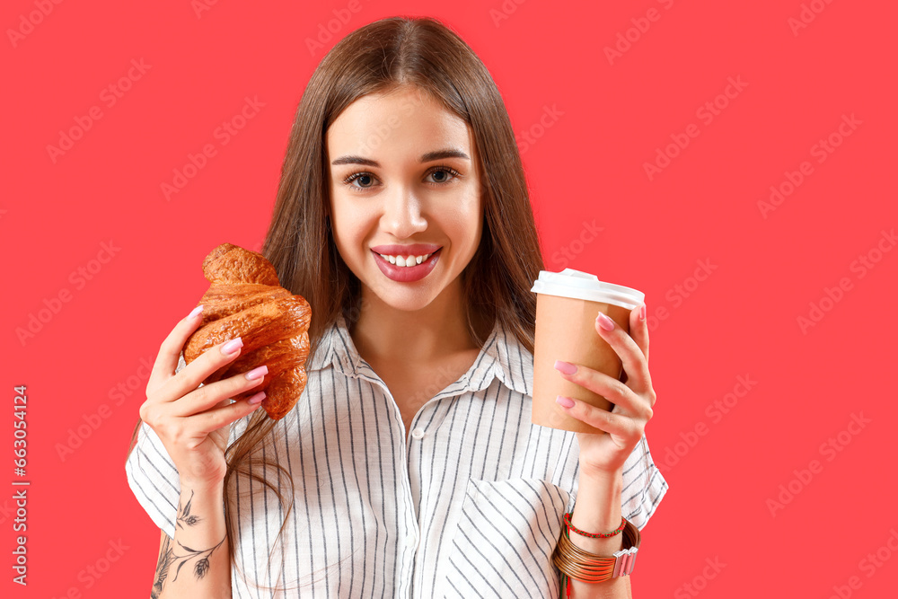 Beautiful happy young woman with tasty croissant and cup of coffee on red background