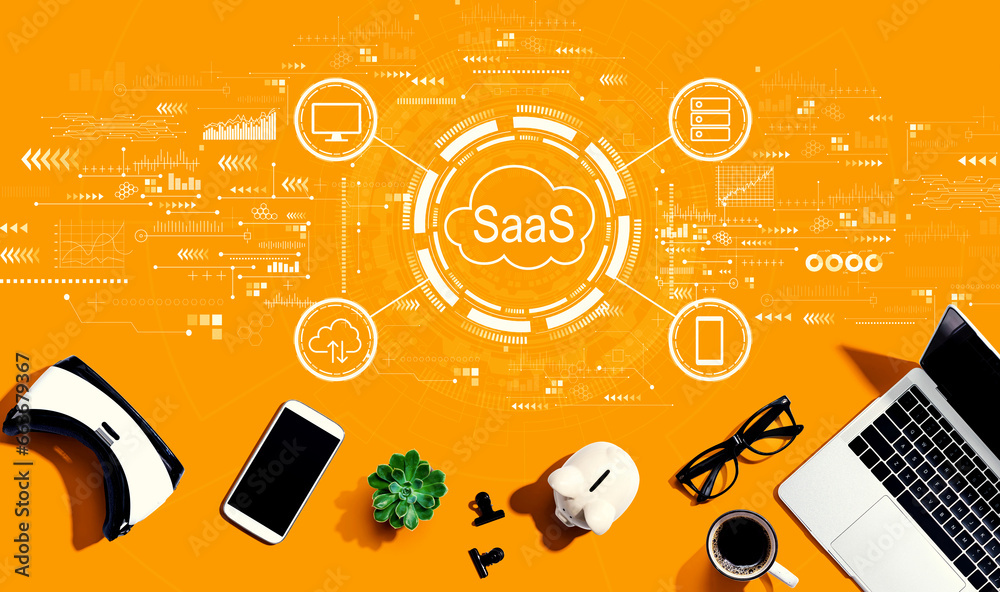 SaaS - software as a service concept with electronic gadgets and office supplies - flat lay