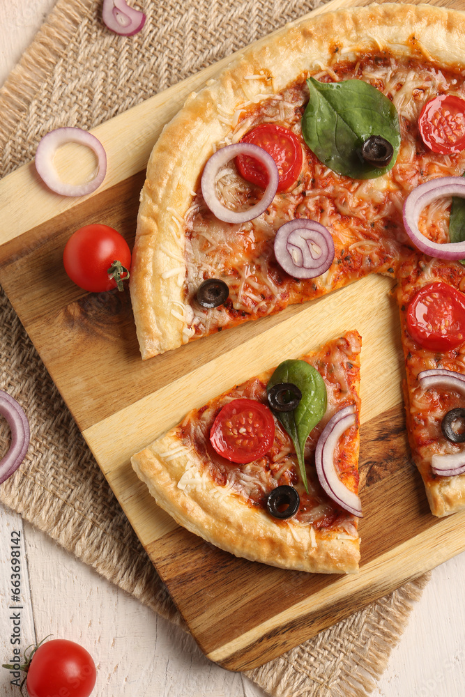 Board of tasty pizza with basil and tomatoes on white wooden background