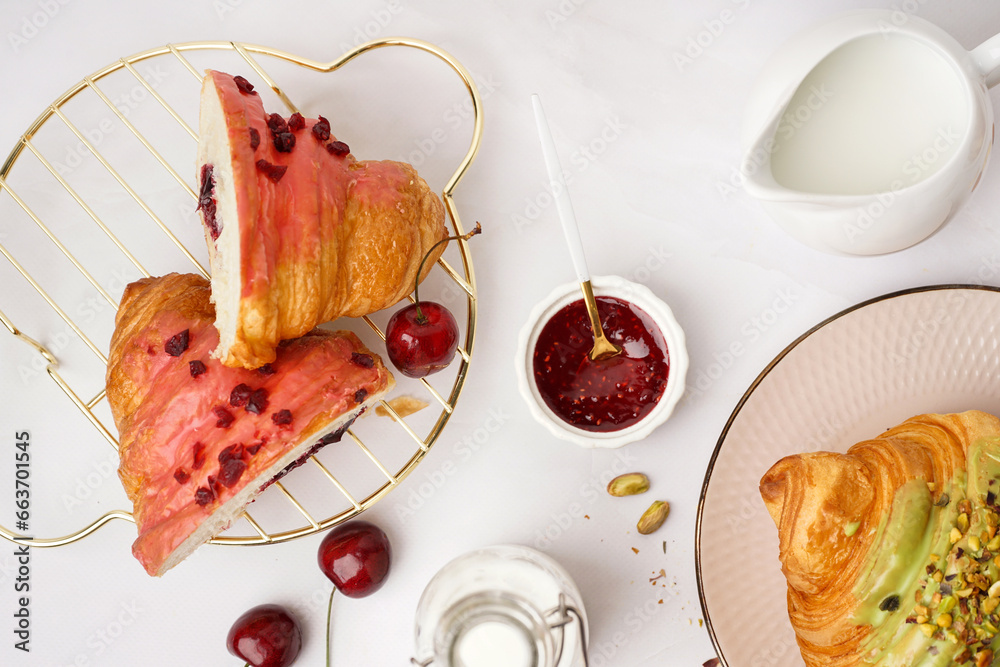 Composition with tasty croissants, jam and milk on light background