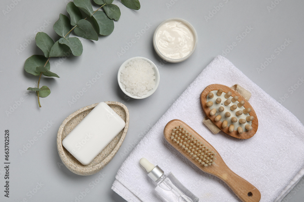 Composition with different bath supplies and eucalyptus branch on grey background