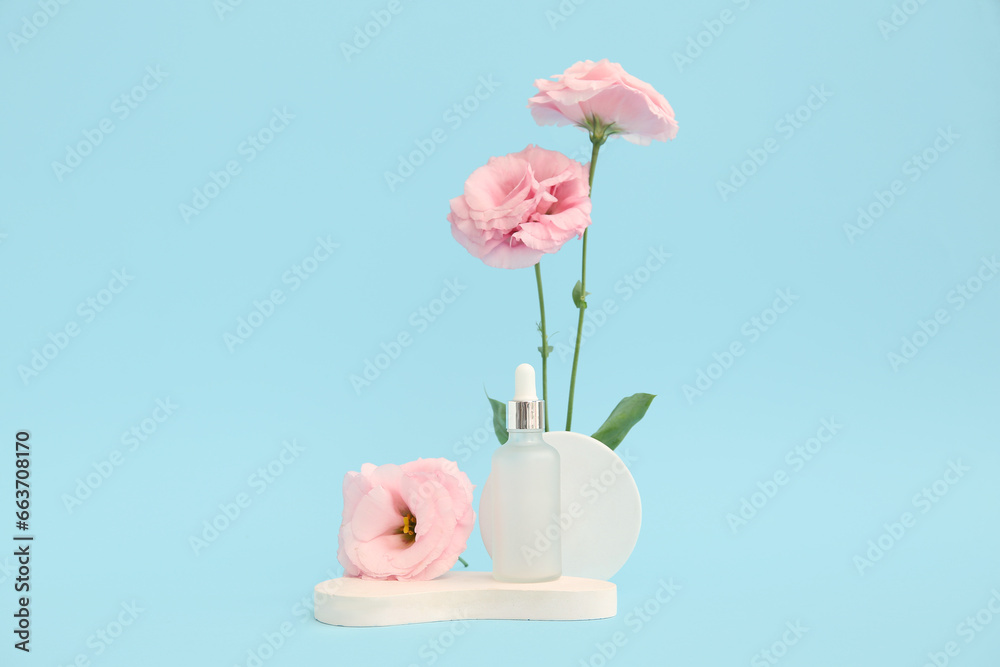 Composition with bottle of essential oil, plaster podium and beautiful eustoma flowers on blue background