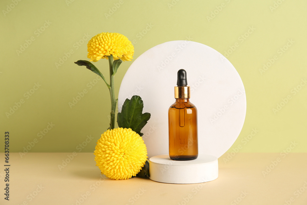 Composition with bottle of essential oil, plaster podium and beautiful chrysanthemum flowers on color background