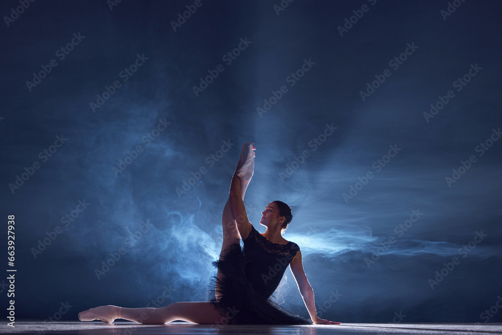 Artistic, talented young woman, professional ballerina making creative performance on sage with smoke effect. Concept of classical dance, art and grace, beauty, choreography, inspiration