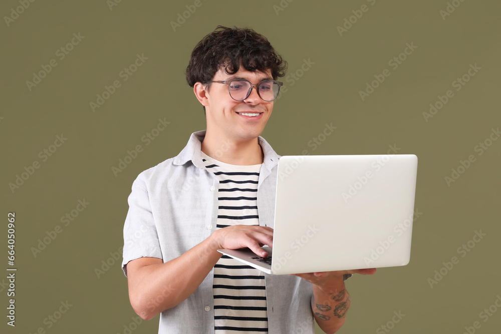 Male programmer working with laptop on green background