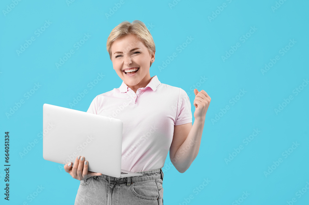 Happy young female programmer with laptop on blue background