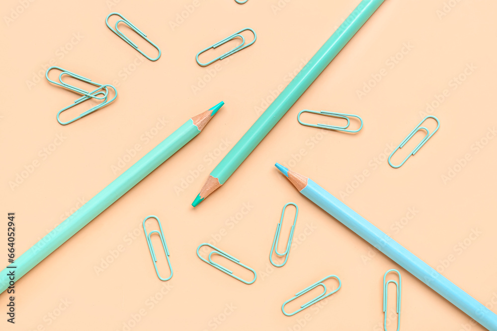 Composition with pencils and paper clips on color background