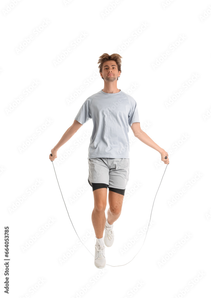 Young man in sportswear jumping with skipping rope on white background