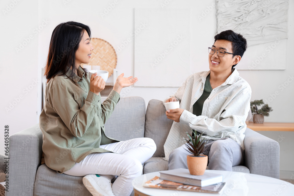 Young Asian friends drinking coffee at home