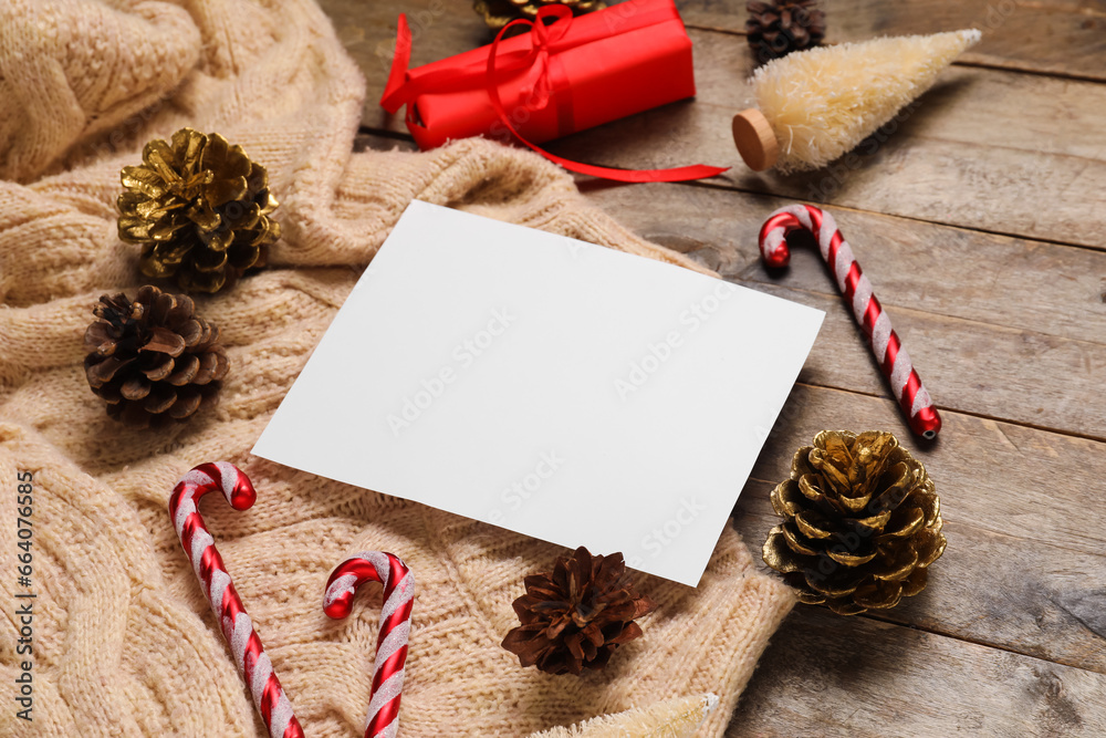 Beautiful Christmas composition with blank card, sweater and decor on wooden background