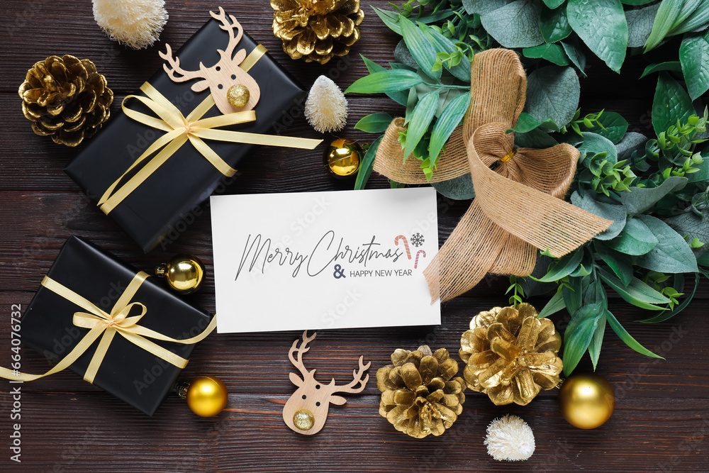 Beautiful Christmas composition with greeting card and decor on black wooden background