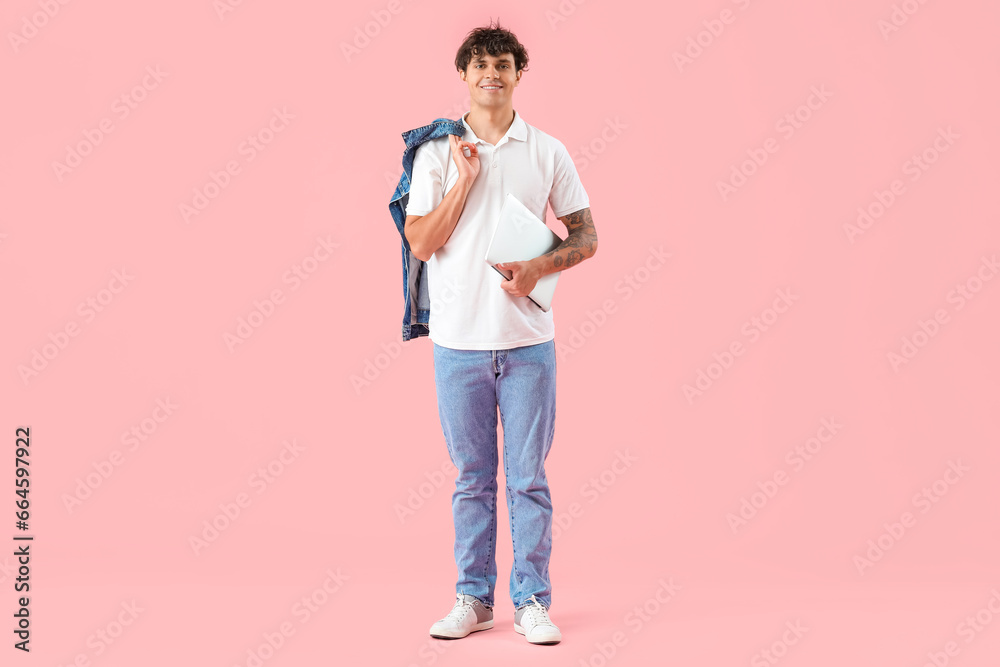 Male programmer with laptop on pink background