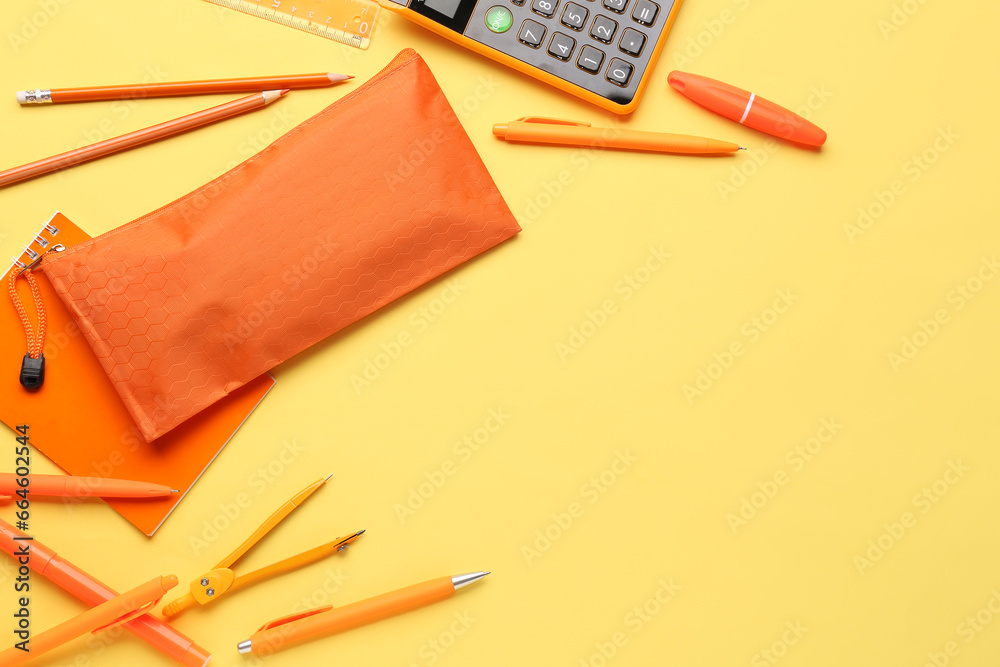 Orange pencil case with school stationery on beige background