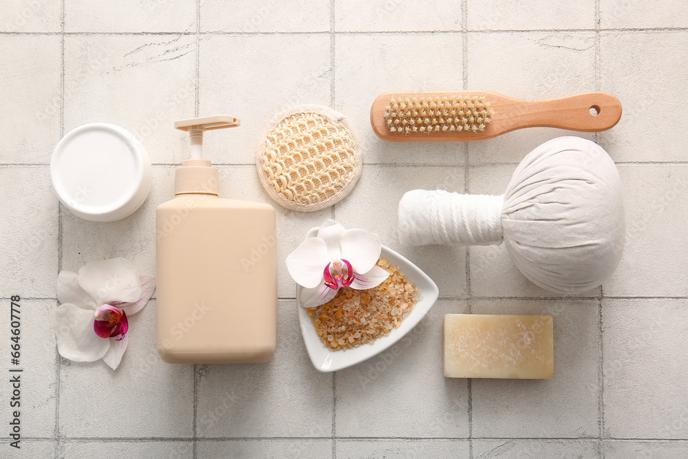 Composition with spa accessories, cosmetics and orchid flowers on light tile background