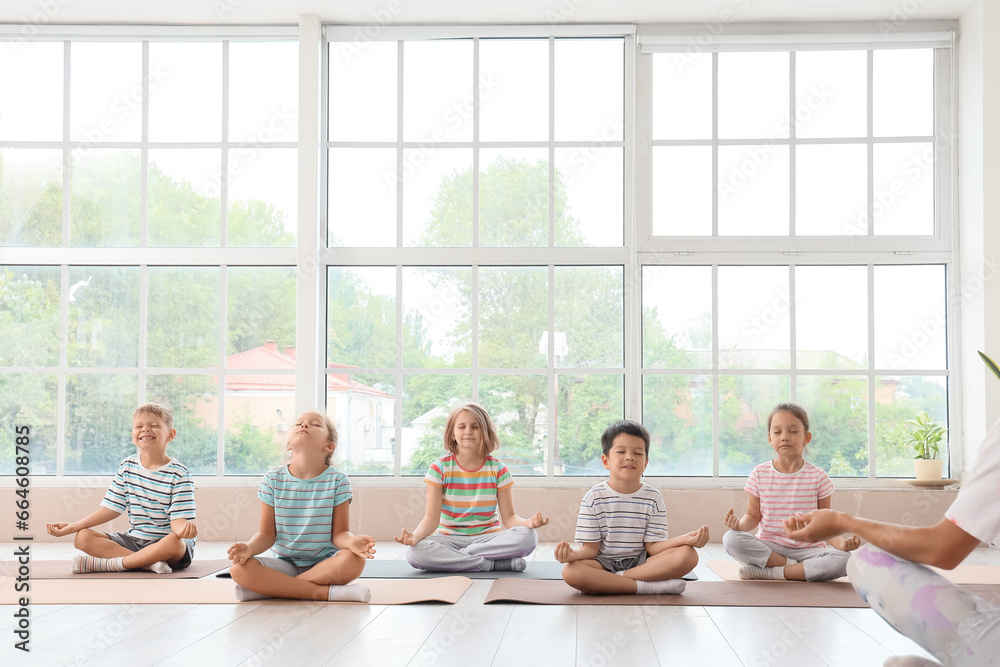 Group of little children meditating in gym