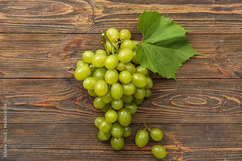 Sweet green grapes with leaf on wooden background