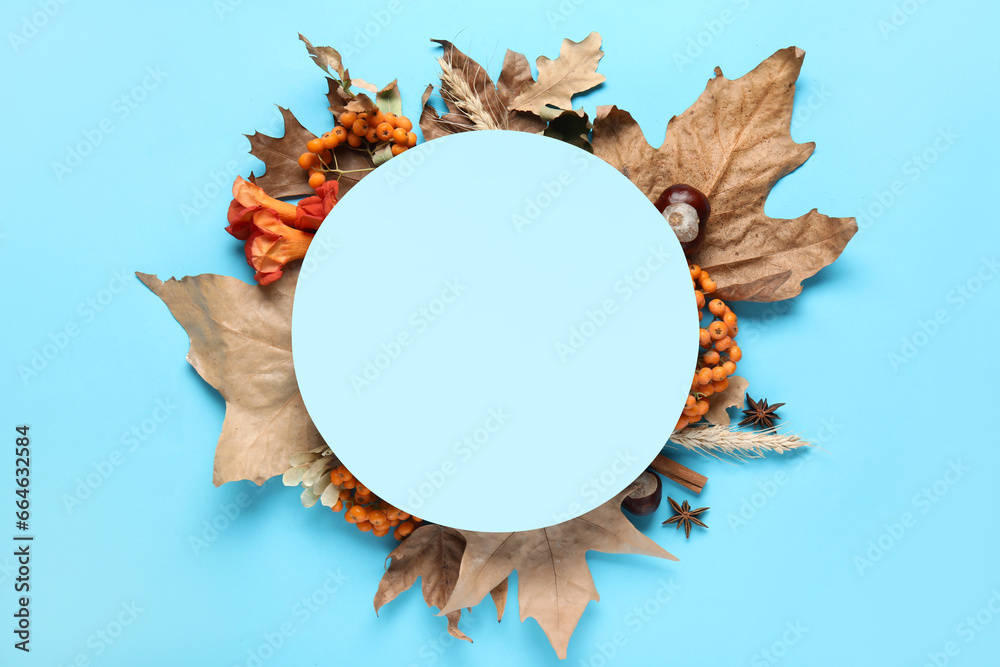 Blank card with autumn leaves, chestnuts and rowan on blue background