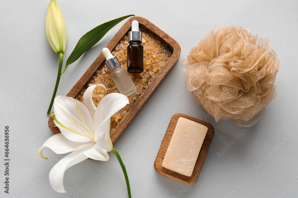 Composition with bath supplies and beautiful lily flowers on grey background