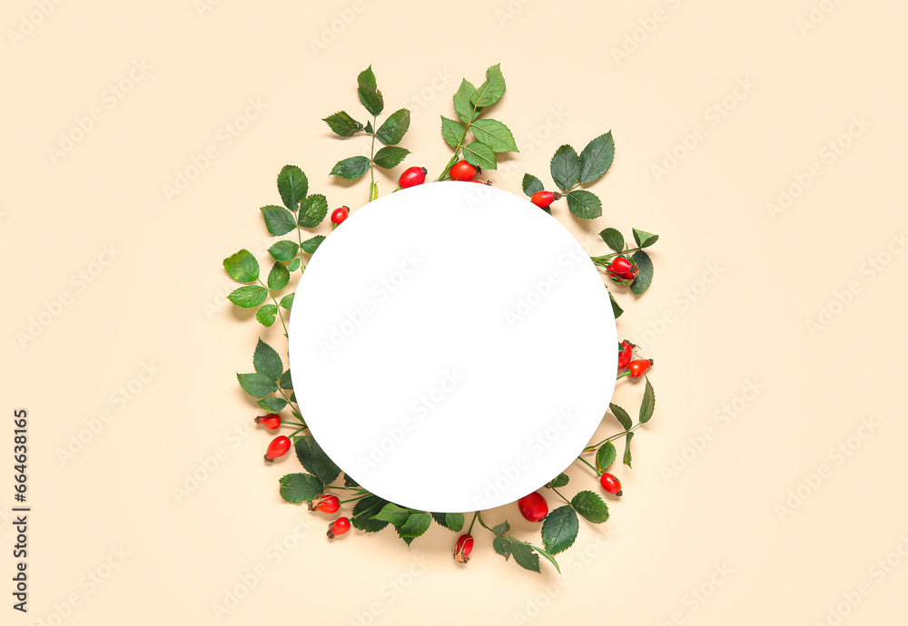 Blank card with fresh rose hip berries and leaves on beige background