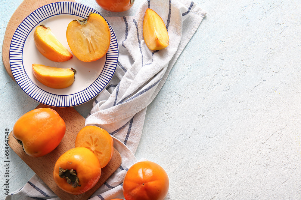 Wooden board and plate with sweet ripe persimmons on white background