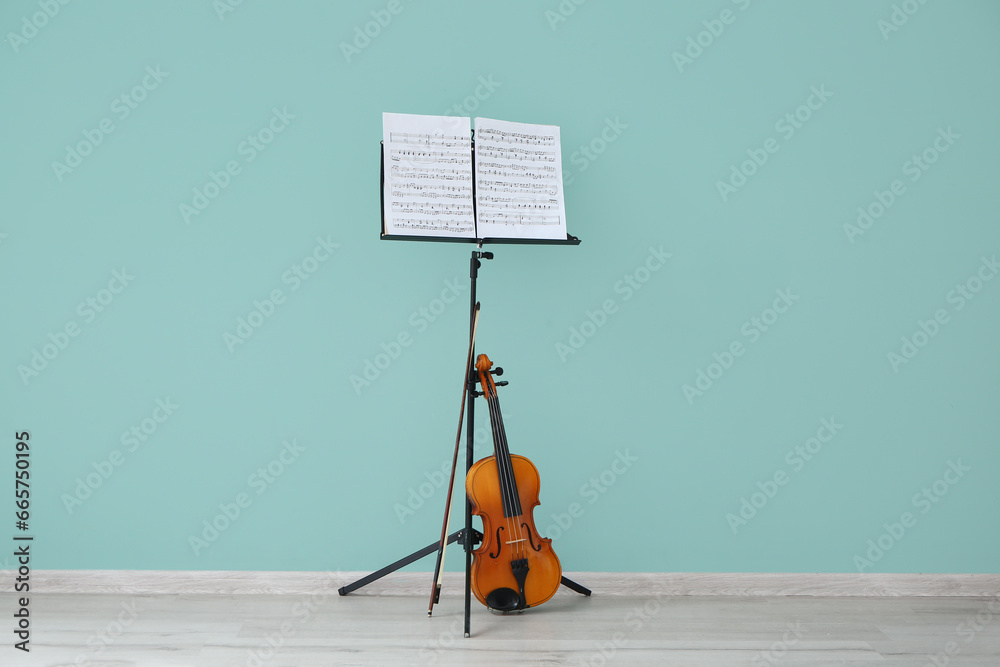 Note stand and violin near color wall