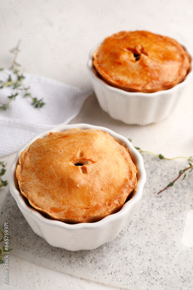 Tasty meat pot pies on light background