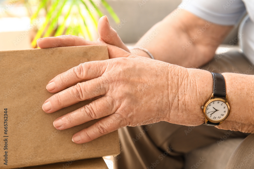 Senior woman with book at home, closeup