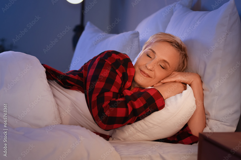 Mature woman sleeping in bed at night