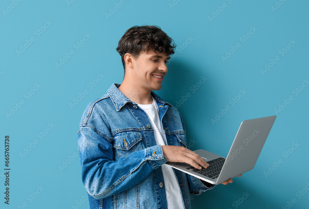 Male programmer working with laptop on blue background