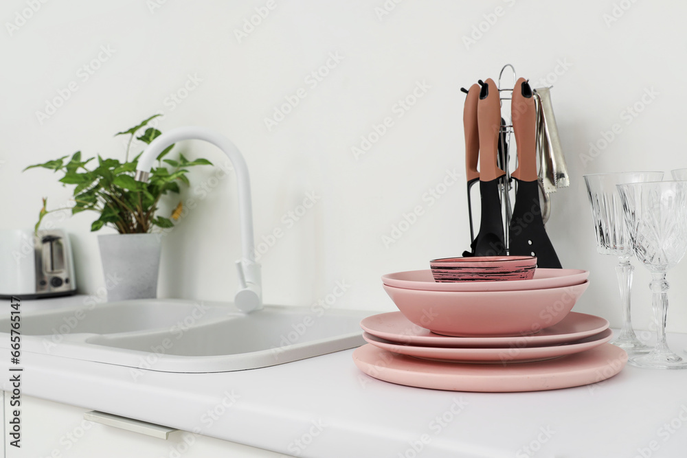 Set of clean pink dishes on counter in kitchen, closeup