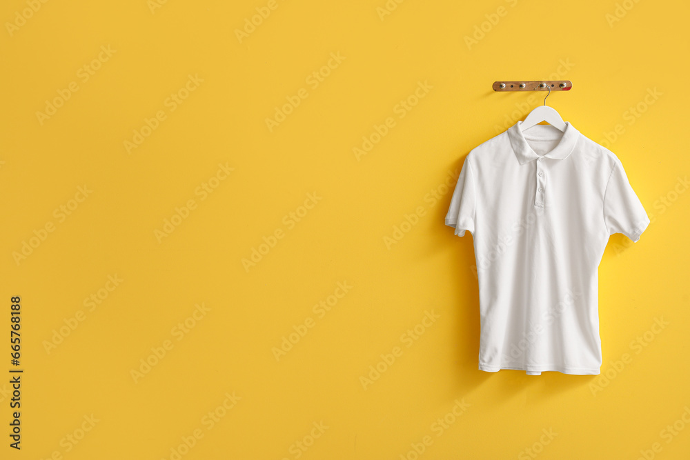 Stylish white t-shirt hanging on yellow background