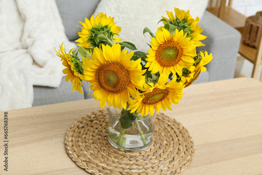 Vase with sunflowers on table in living room, closeup