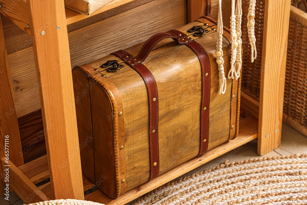 Wooden suitcase on shelf in room, closeup