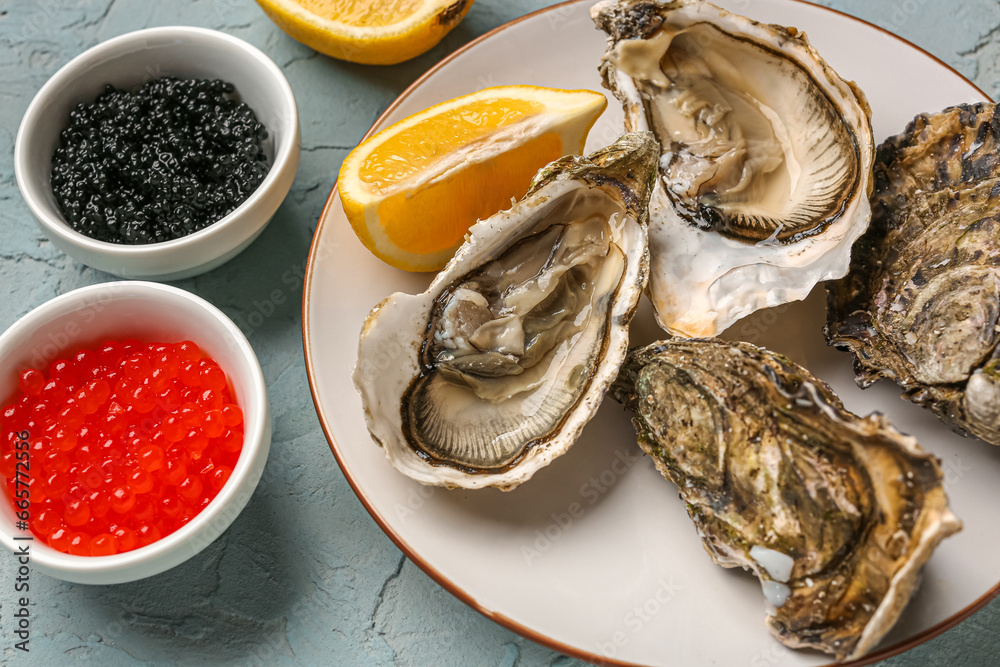 Plate of tasty oysters with lemon, black and red caviar on grey background