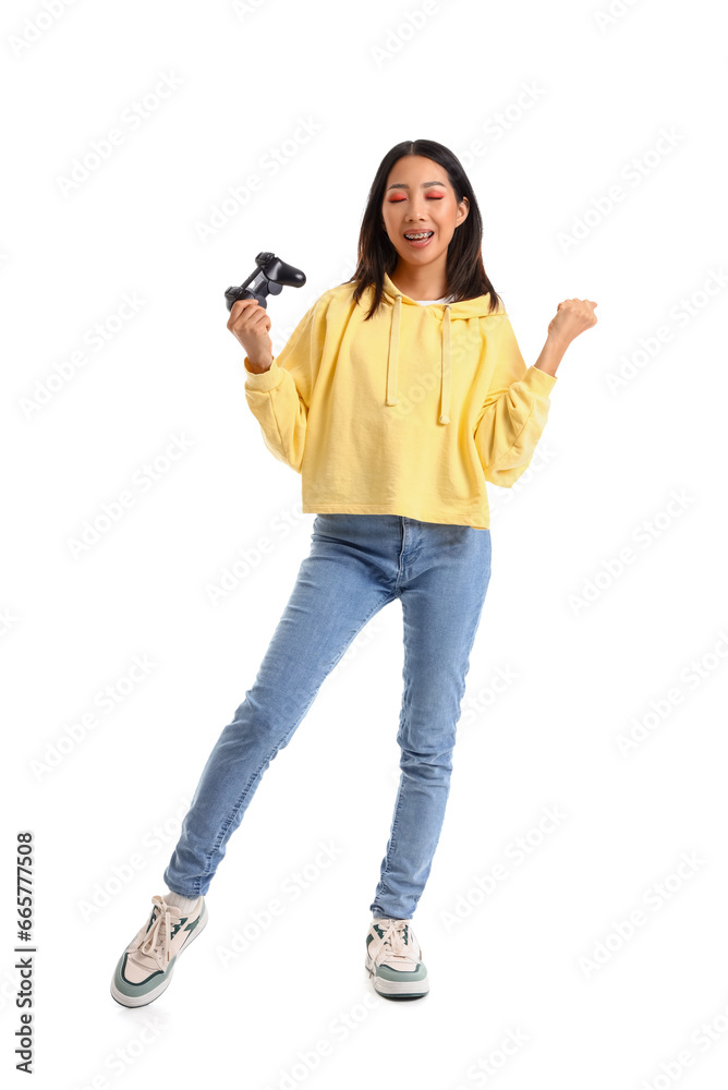 Young Asian woman in yellow hoodie with game pad on white background