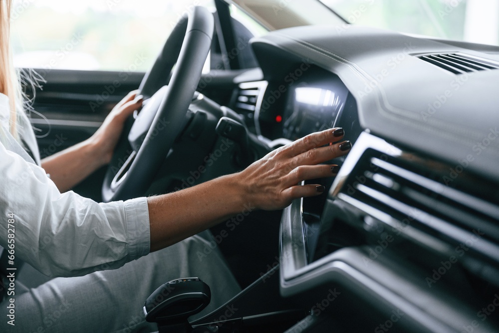 Close up view. Woman is sitting in a car and driving it