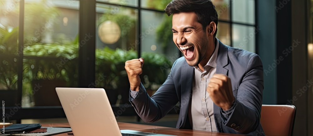 Ecstatic winner of Indian descent watching virtual lottery results shaking hands at desk Eastern student receives job proposal after perfect exam grades