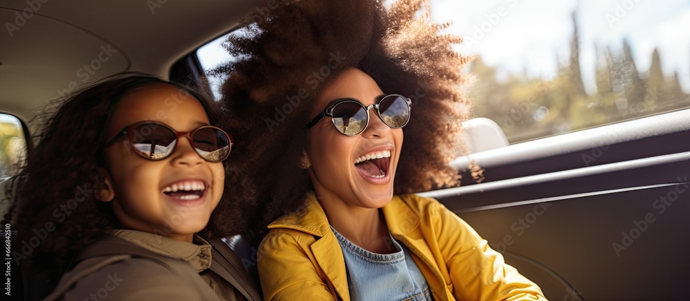 African American daughter and mother enjoying road trip in car