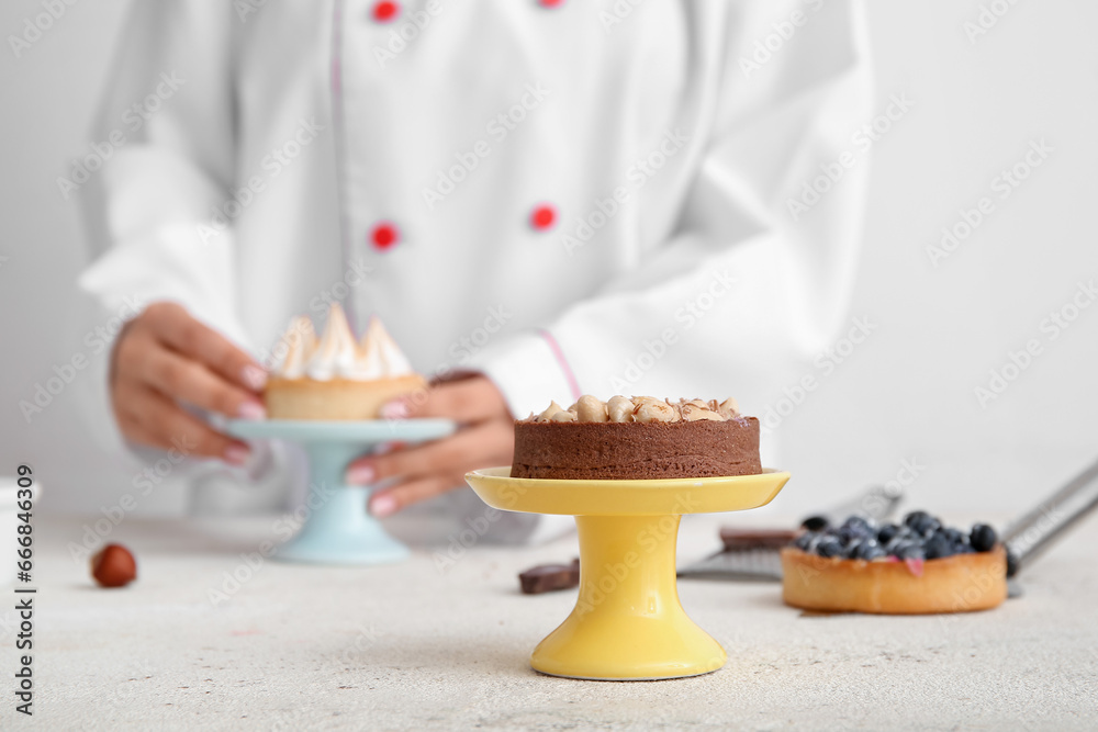 Stand with tasty cake on white background