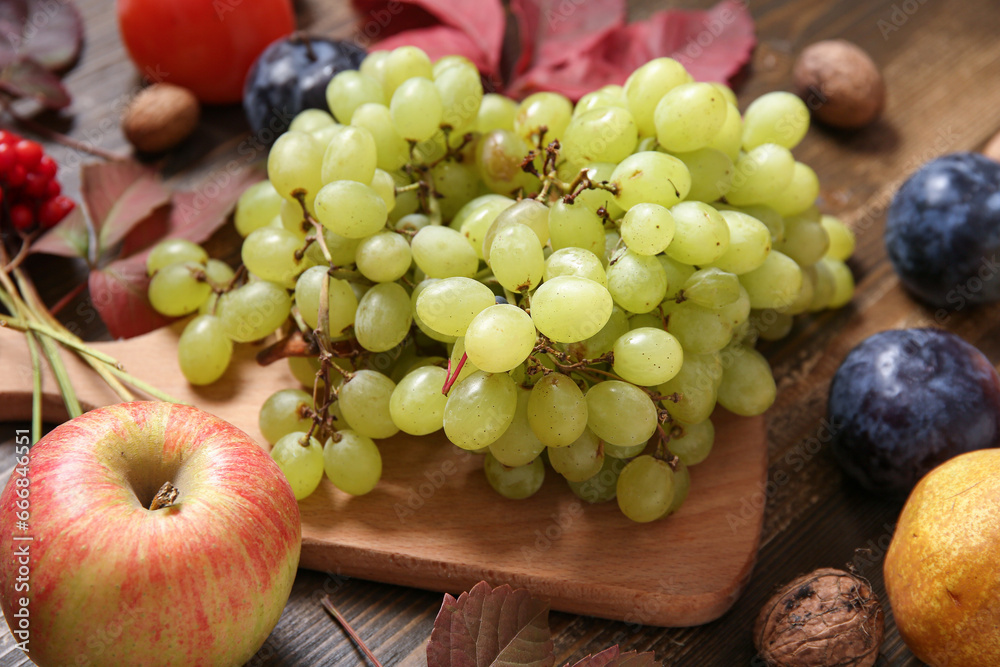 Board with different fresh fruits on wooden background