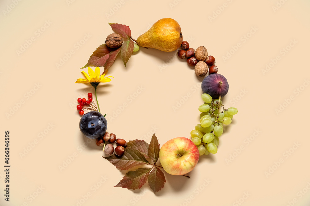 Frame made of different fresh fruits, nuts and leaves on beige background