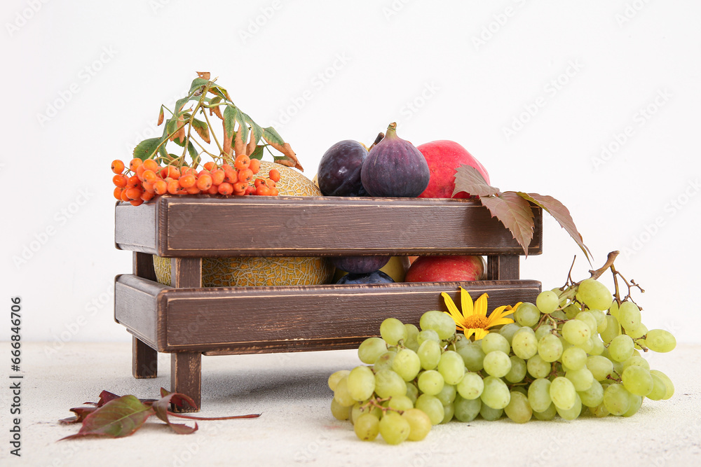 Wooden box with different fresh fruits on white background