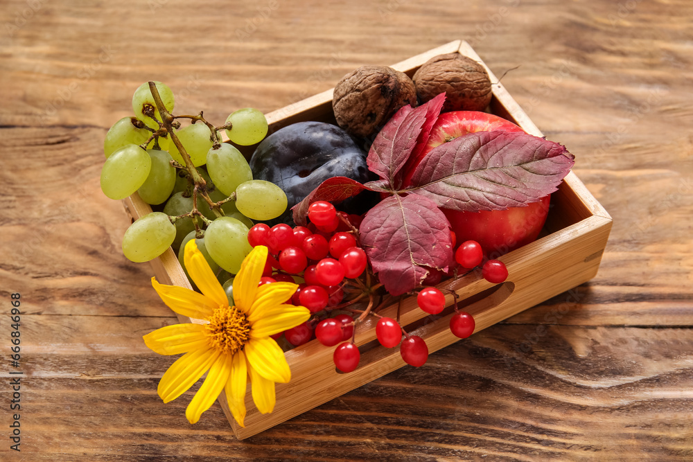 Box with different fresh fruits on wooden background