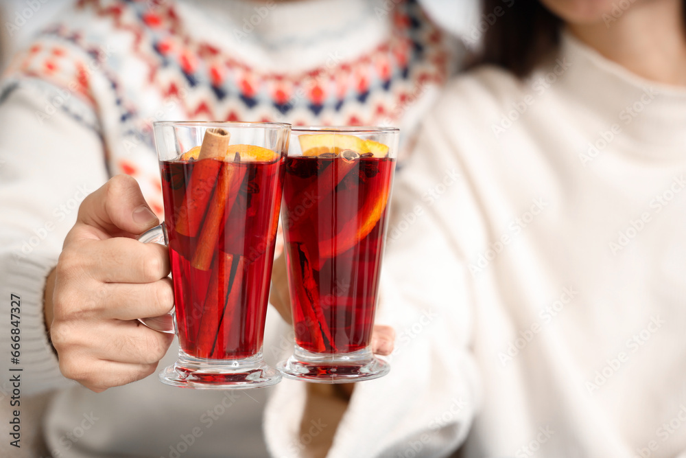 Happy couple with glasses of warm mulled wine, closeup