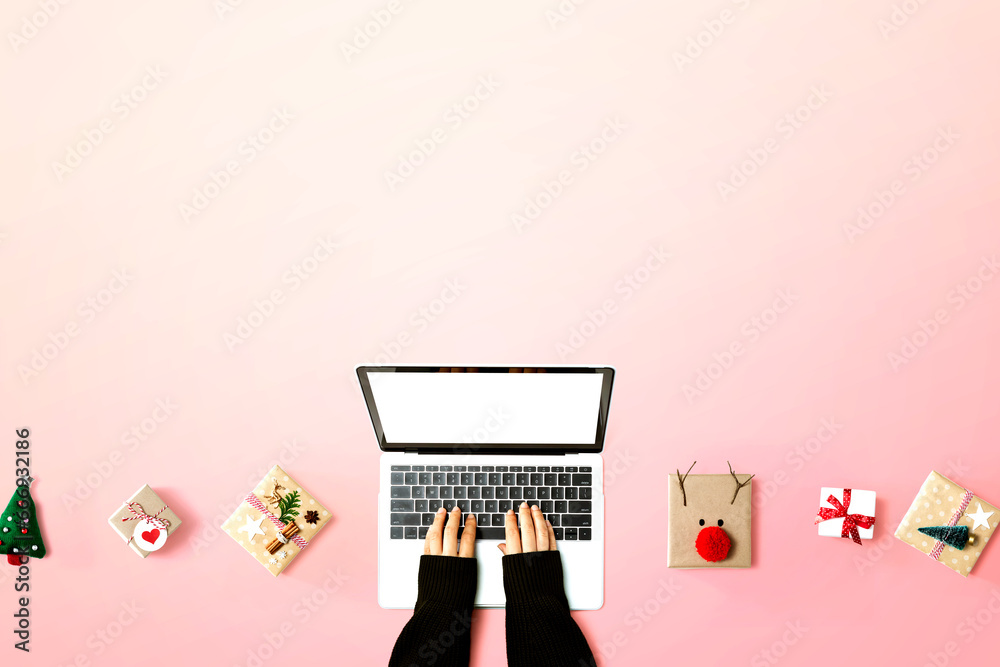 Person using a laptop computer with Christmas gift boxes from above