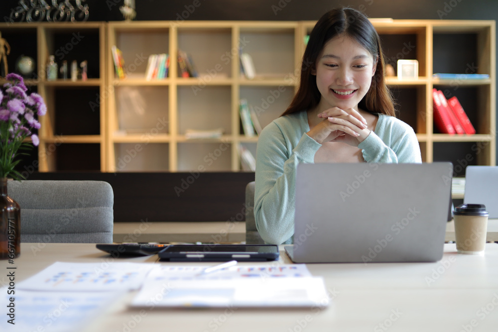 Students studying online on laptops in university library. Asian woman working with laptop in office.